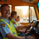 Conducteur d'autobus souriant au volant le matin avec enfants