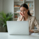 Jeune femme en bureau moderne lisant un email